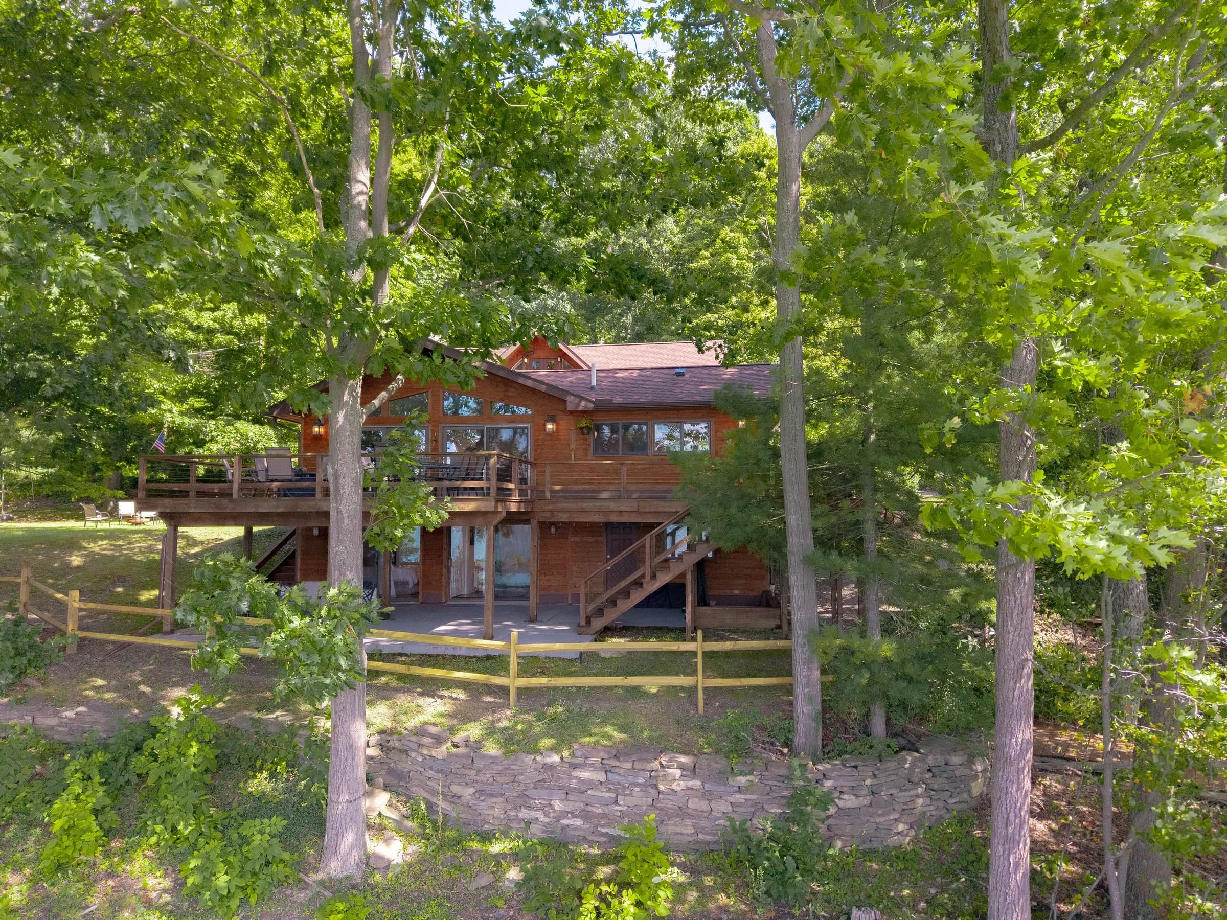 Lakeside Landing FLX main house — cedar-shake with a two-tier deck and floor-to-gable lake windows
