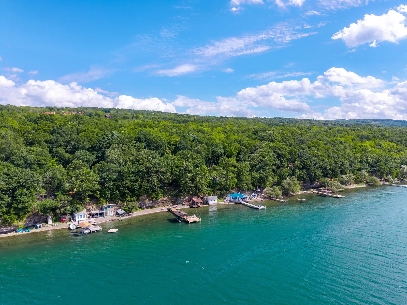 Aerial view of Lakeside Landing FLX on the east shore of Seneca Lake, with private docks, shale beach and forested bluff