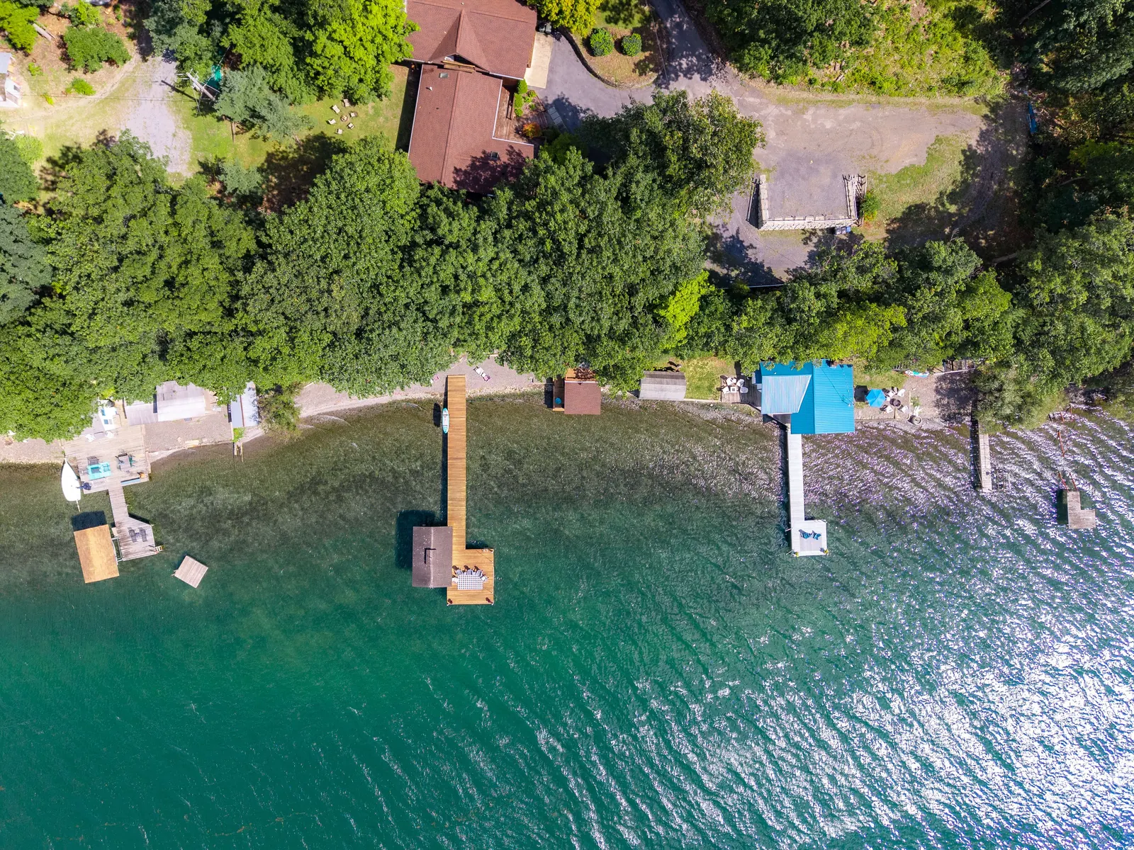 Drone view of the east shore of Seneca Lake with private waterfront and forested bluff