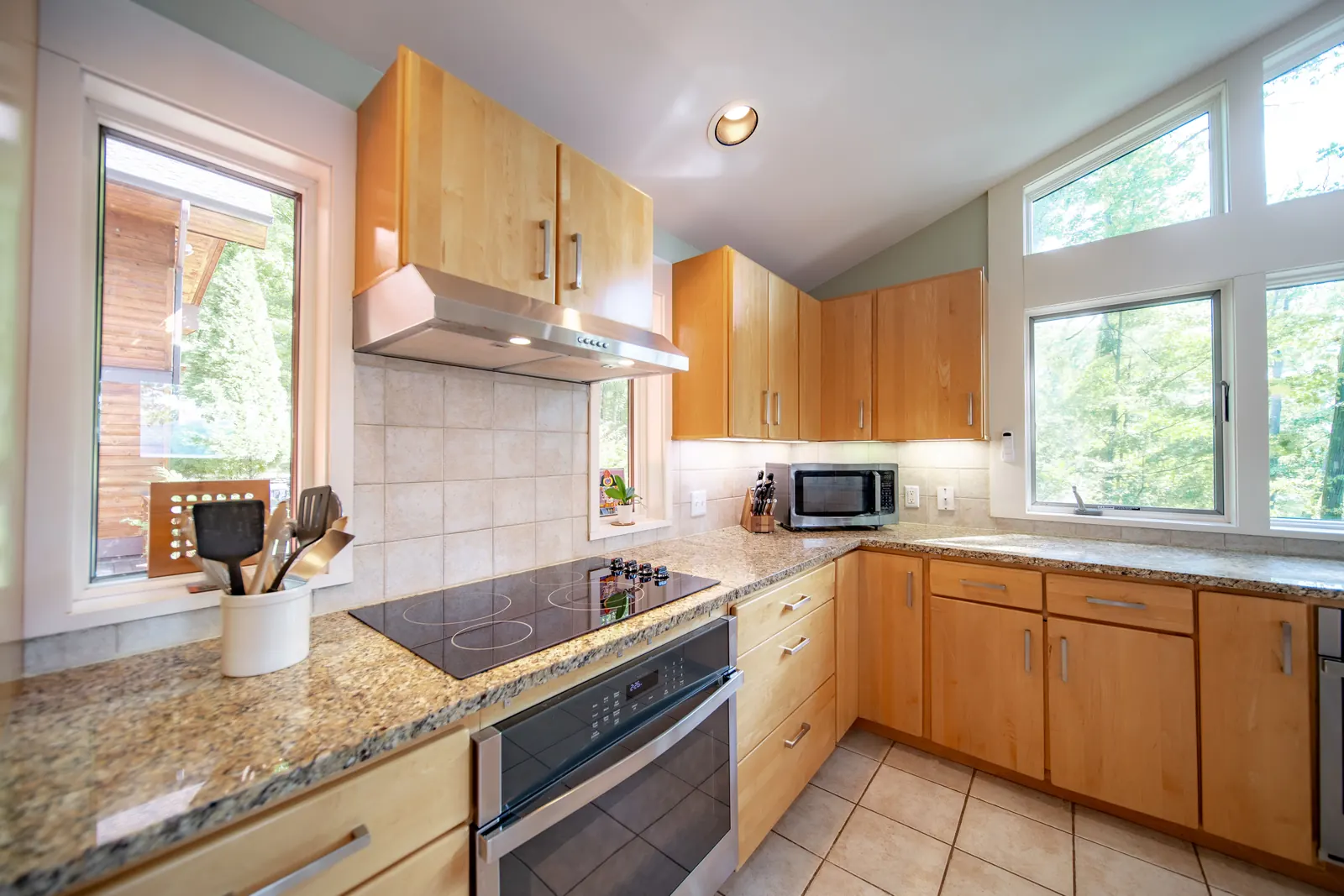 Kitchen at Lakeside Landing FLX — range and granite counters, tile backsplash, natural light from tall windows