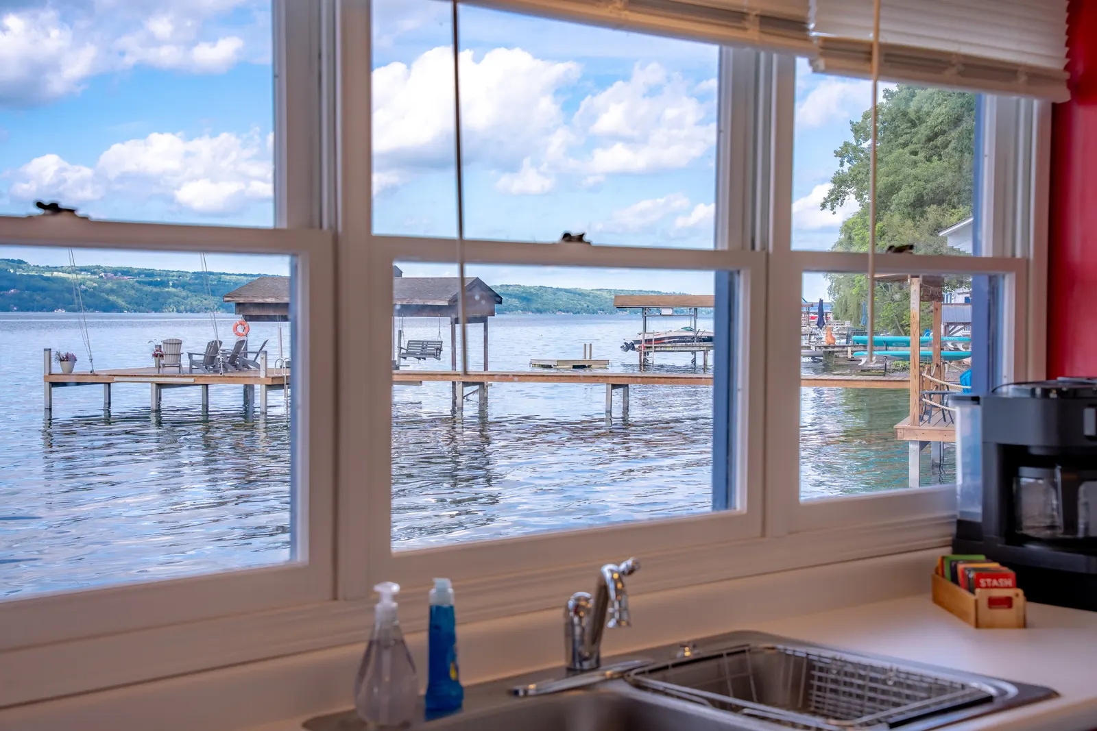 The 150-degree water view from the Smooth Sailing kitchen sink — docks in the near shore, lake to the horizon